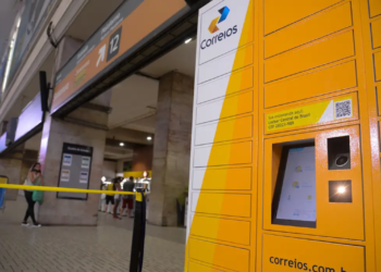 Terminal de correios com um locker inteligente, simbolizando o serviço de entrega e os concursos para cargos nos Correios.