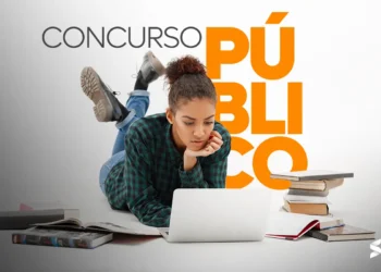 Pessoa estudando para concurso público, com livros e laptop ao seu redor