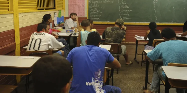 Alunos participando de aula de recuperação ou de educação de jovens e adultos.