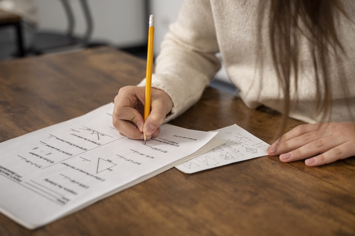 Pessoa resolvendo uma prova de matemática, simbolizando a importância da preparação para o Concurso Nacional Unificado.