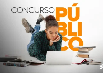 Pessoa concentrada estudando para concurso público com livros e laptop, ilustrando o início de uma jornada de preparação