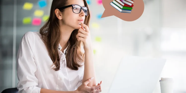 Mulher pensando enquanto trabalha em computador, simbolizando o equilíbrio entre estudo e trabalho.