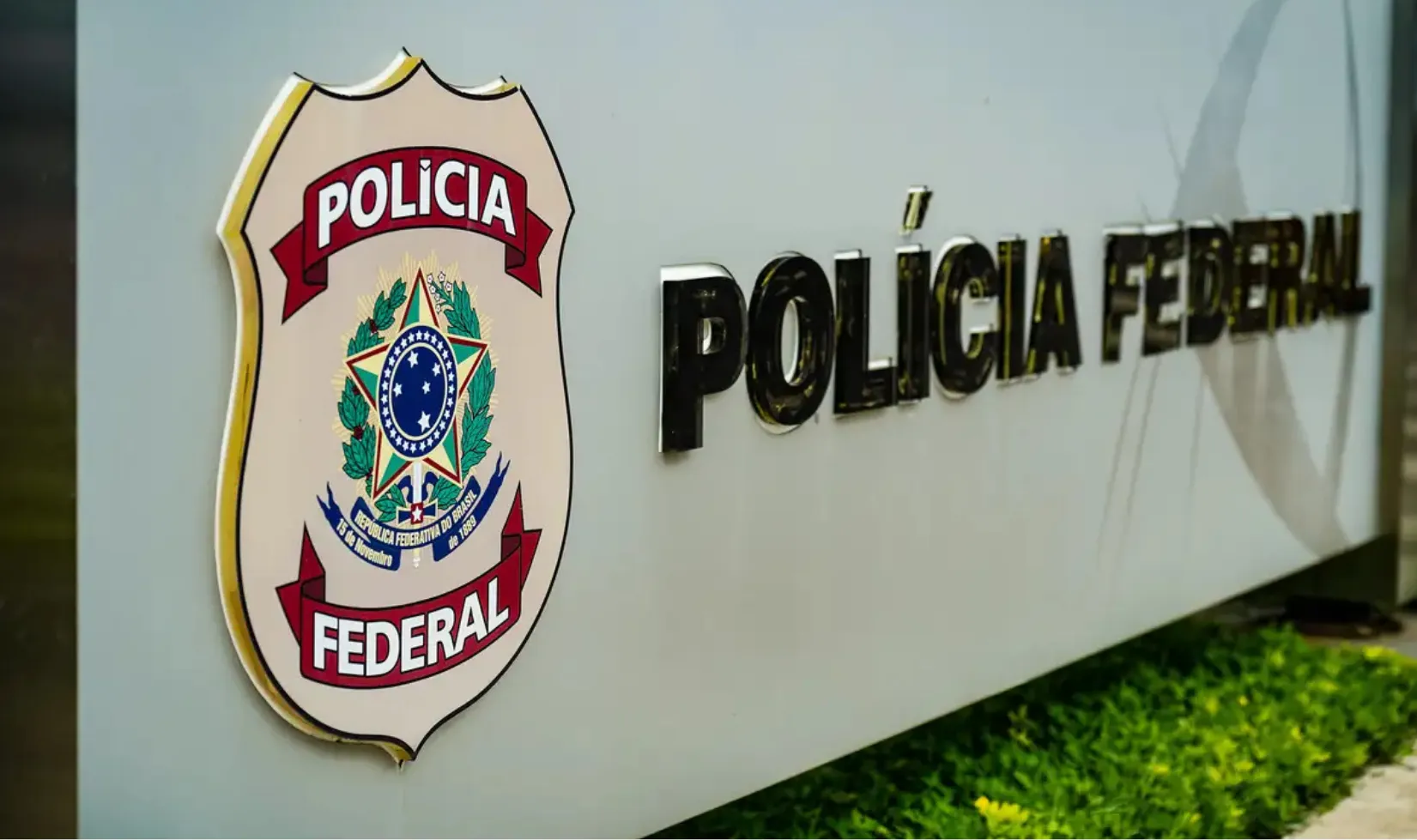 Placa com o brasão e o nome da Polícia Federal, representando a instituição responsável pelo concurso público.