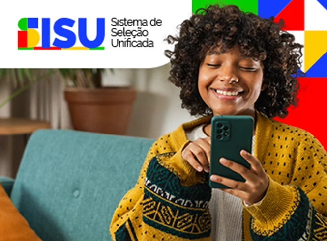 Jovem sorrindo e usando um celular para consultar o resultado da lista de espera do Sisu