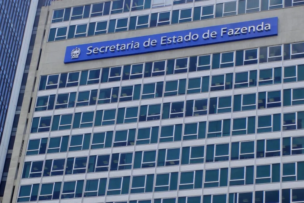 Fachada de um prédio com a placa "Secretaria de Estado de Fazenda", representando editais publicados para concursos fiscais.