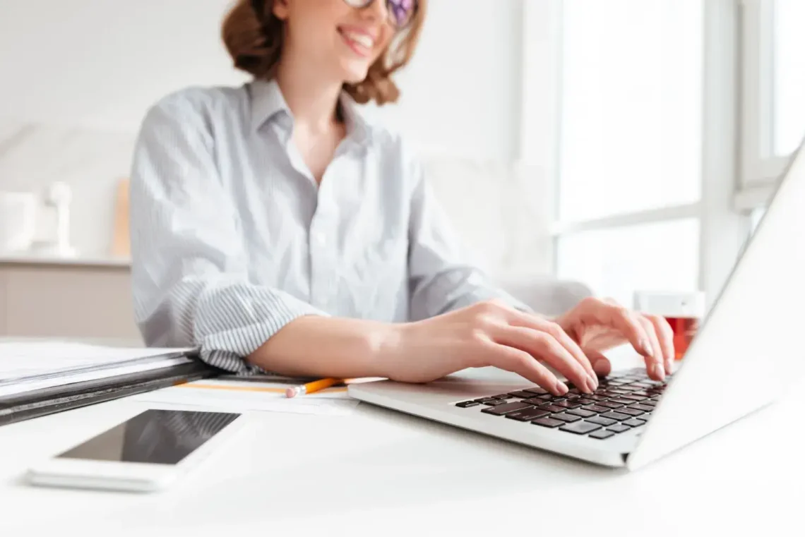 Mulher digitando no notebook para realizar inscrição online em um processo seletivo