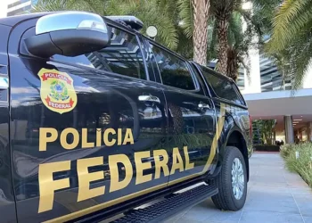 Viatura da Polícia Federal estacionada em frente a um prédio.