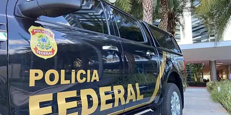 Viatura da Polícia Federal estacionada em frente a um prédio.