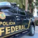 Viatura da Polícia Federal estacionada em frente a um prédio.