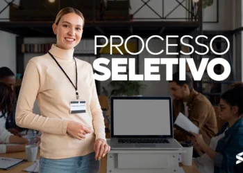 Mulher sorrindo ao lado de um laptop em ambiente corporativo, com a inscrição "Processo Seletivo" destacada na imagem