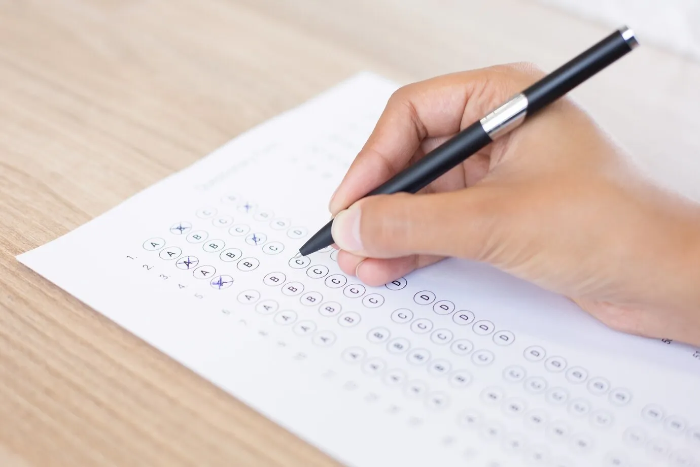 Pessoa respondendo questões de múltipla escolha, representando a preparação para um processo seletivo