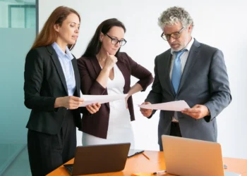 Equipe de profissionais analisando documentos em reunião de trabalho, representando a profissão que mais cresce no Brasil