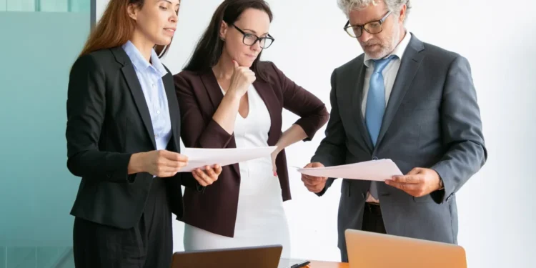 Equipe de profissionais analisando documentos em reunião de trabalho, representando a profissão que mais cresce no Brasil