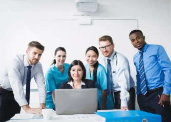 Equipe de profissionais da saúde e gestão reunidos para discutir estratégias, representando áreas com altos salários de entrada