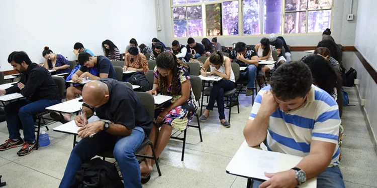 Estudantes realizando uma prova em sala de aula, concentrados no exame.