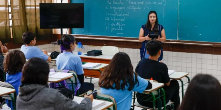 Educadora ensinando em sala de aula para alunos.