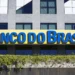 Fachada de uma agência do Banco do Brasil com letreiro azul e amarelo.