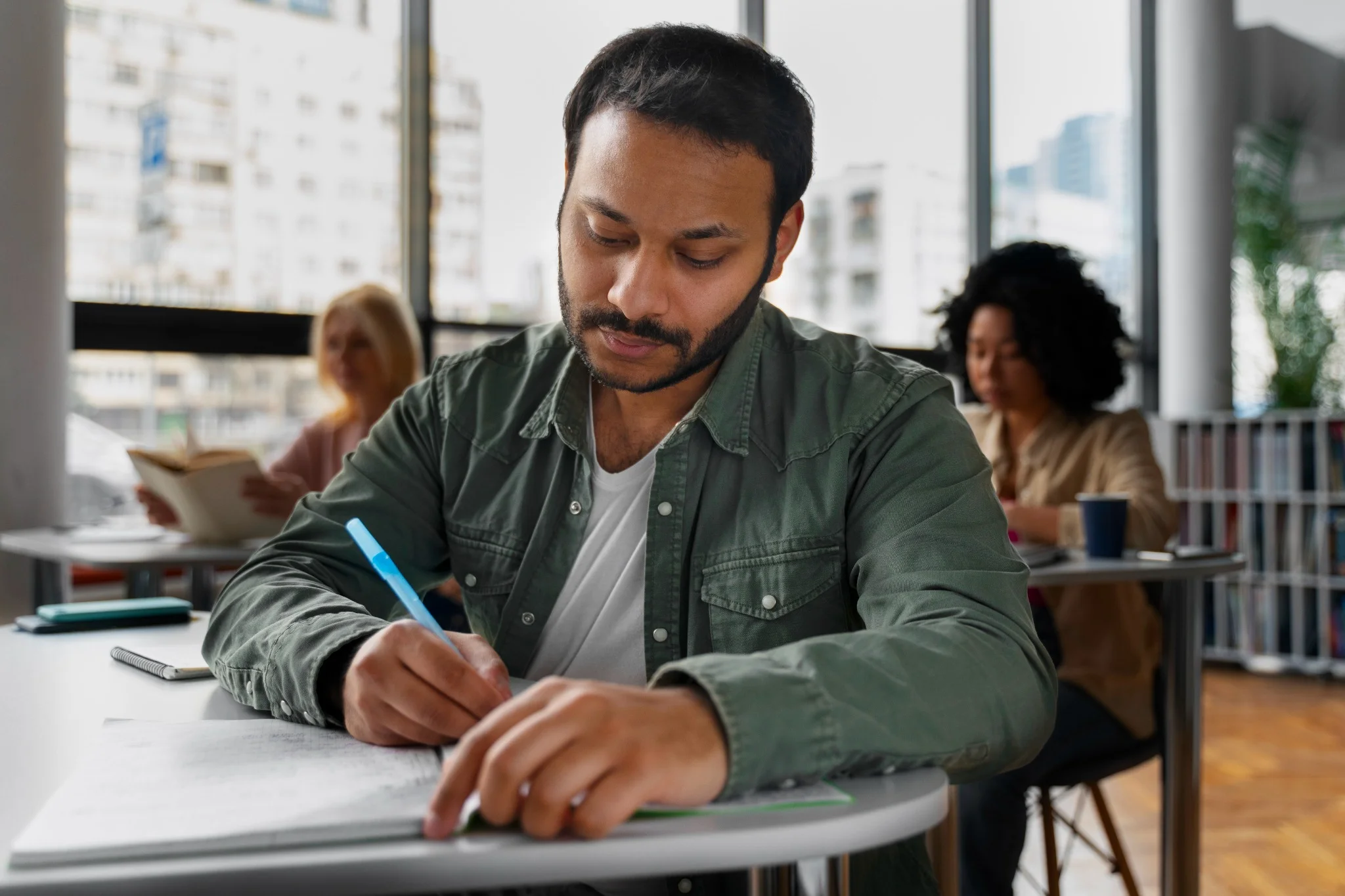 Homem estudando e fazendo anotações em preparação para o concurso Sefaz PR.