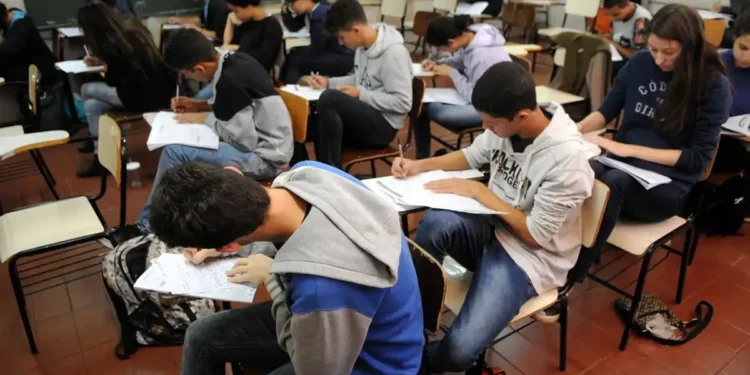 Grupo de estudantes realizando prova em sala de aula