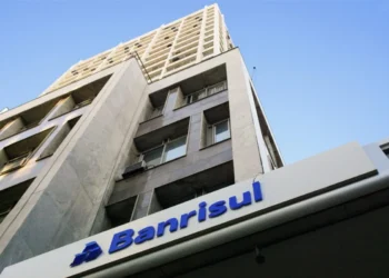 Fachada do edifício do Banrisul vista de baixo para cima contra o céu azul.