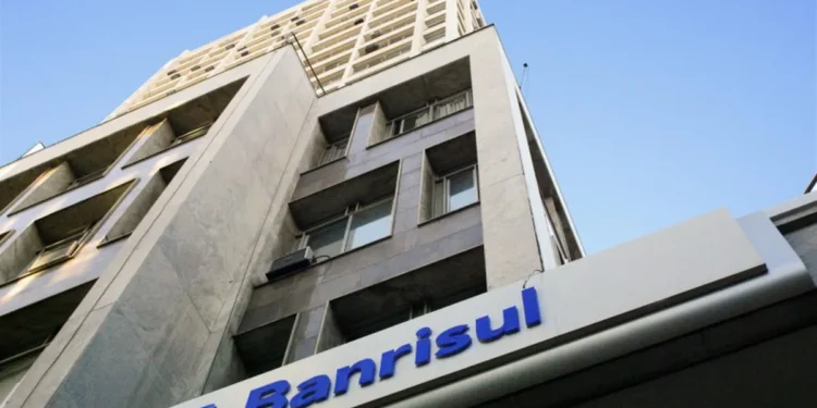 Fachada do edifício do Banrisul vista de baixo para cima contra o céu azul.