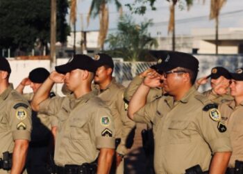 Grupo de policiais militares do Tocantins fardados realizando saudação militar durante treinamento.
