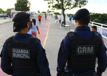 Dois guardas municipais em patrulha, promovendo a segurança pública em uma área urbana.