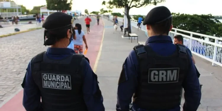 Dois guardas municipais em patrulha, promovendo a segurança pública em uma área urbana.