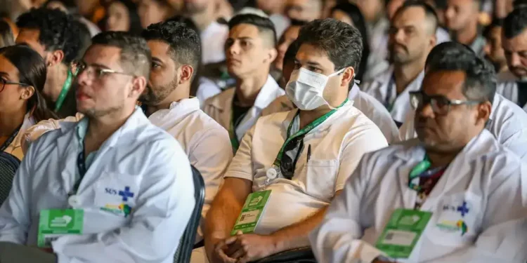 Profissionais de saúde do programa Mais Médicos assistindo a uma palestra