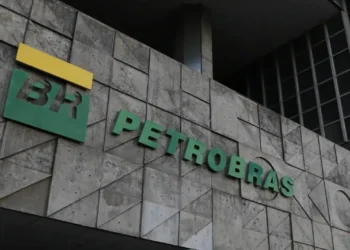 Logo da Petrobras em frente ao prédio corporativo, mostrando o nome e a marca da empresa.