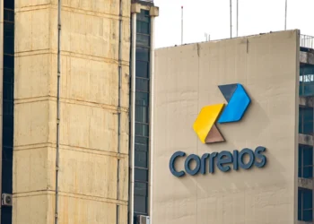 Logo dos Correios em um edifício, destacando a marca azul e amarela.