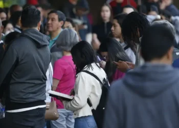 Grupo de pessoas aguardando em fila para um concurso público.