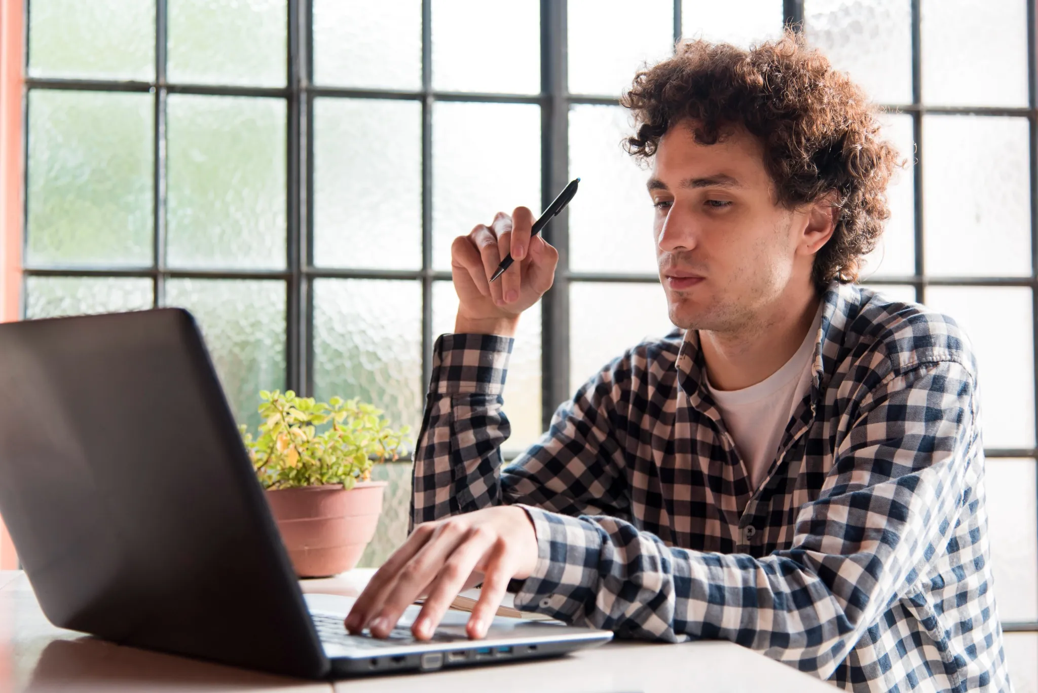 Homem mexendo no computador acessando a página de concurso público.