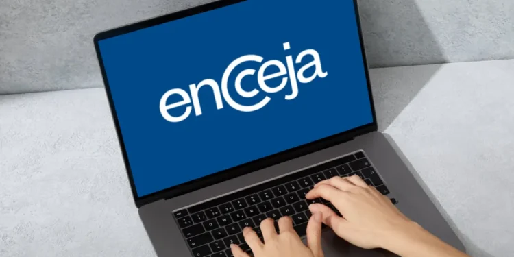 Pessoa digitando no computador com a tela exibindo o logo do Encceja.