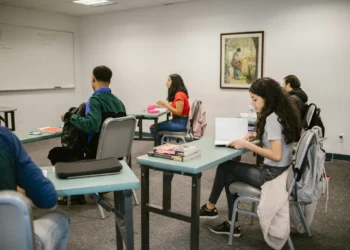 Estudantes em sala de aula, com livros e materiais, ilustrando a oferta de cursos gratuitos de idiomas.