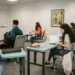 Estudantes em sala de aula, com livros e materiais, ilustrando a oferta de cursos gratuitos de idiomas.