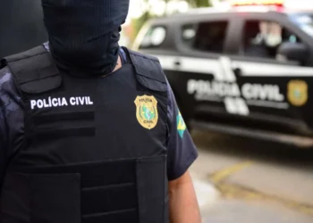 Agente da Polícia Civil em operação, com colete à prova de balas, durante a fase da Operação Alcateia.