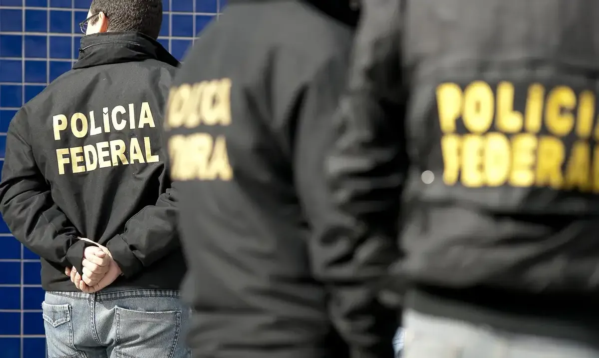 Agentes da Polícia Federal com uniformes durante operação.