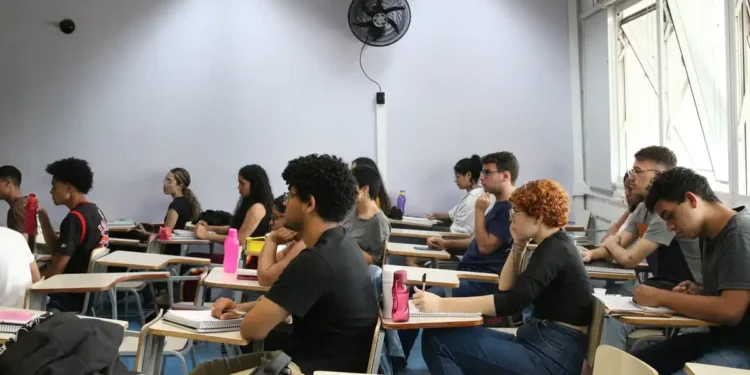 Estudantes sentados em sala de aula, assistindo à aula em uma universidade.