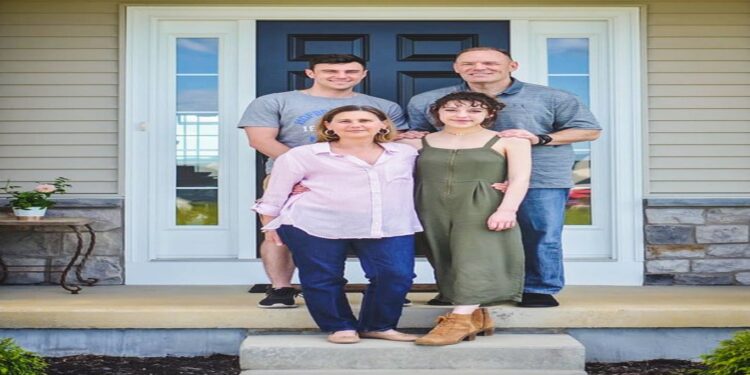 Desafio visual com uma família sorridente em frente à porta da casa, com dois adultos e dois jovens reunidos na entrada.