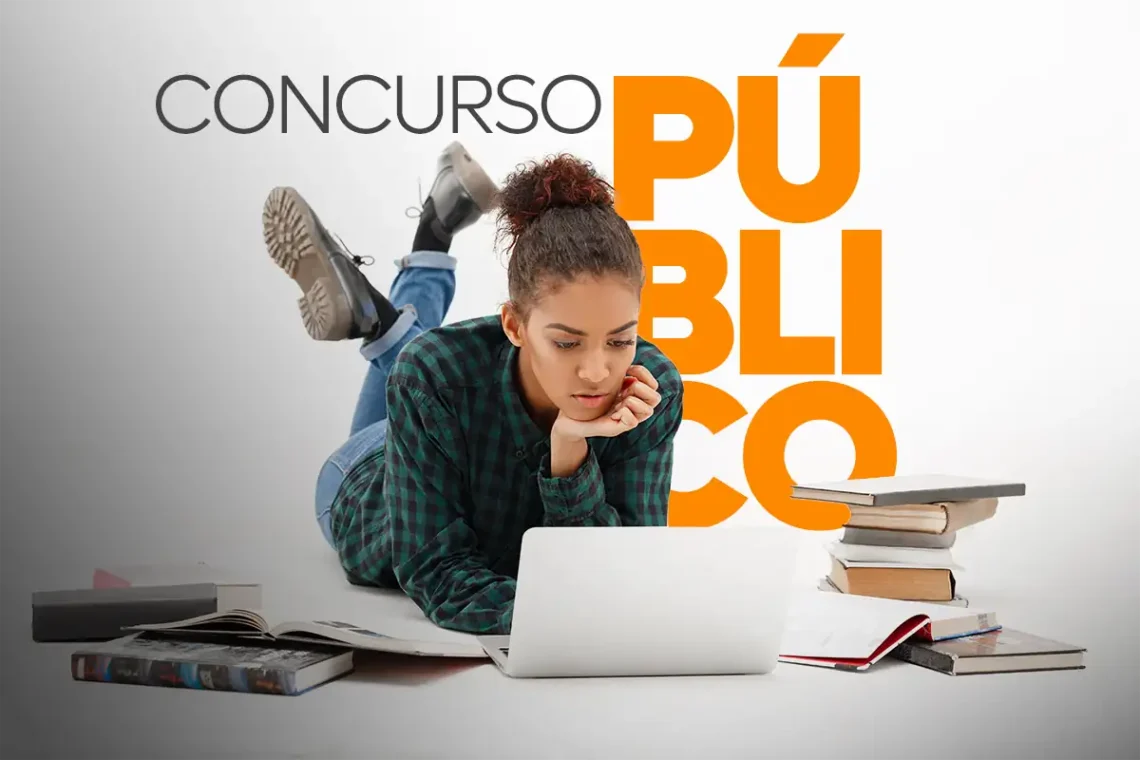 Jovem concentrada estudando para concursos públicos do RJ com laptop e livros