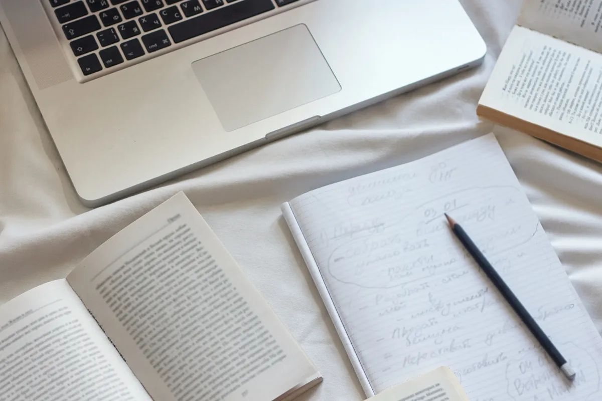 Mesa de estudo com laptop, livros e caderno com anotações