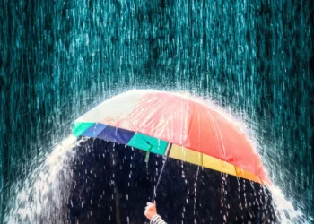 Guarda-chuva colorido protegendo da forte chuva noturna.