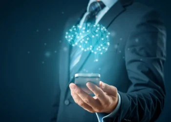 Homem de terno segurando um celular com uma representação digital de um cérebro futurista acima dele.