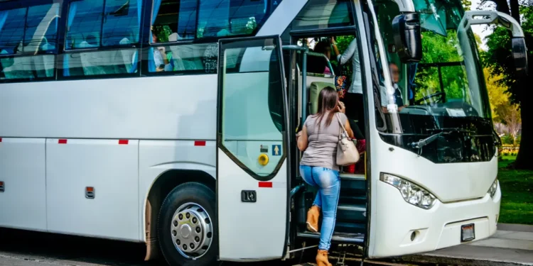 Mulher entrando em ônibus branco urbano