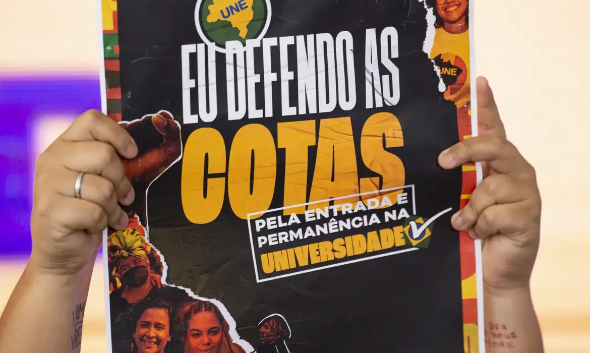 Cartaz que defende a permanência das cotas para negros nas universidades, com a frase 'Eu defendo as cotas'.
