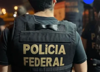 Policial Federal com colete identificador da Polícia Federal durante operação.