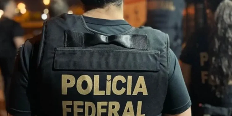 Policial Federal com colete identificador da Polícia Federal durante operação.
