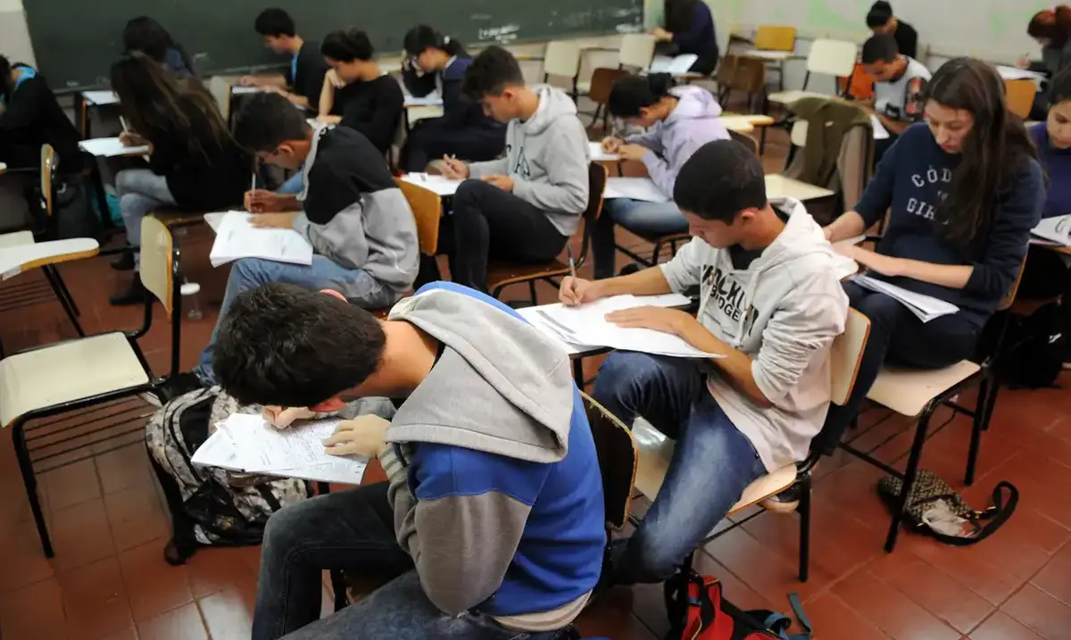 Grupo de estudantes realizando um simulado do Enem em uma sala de aula.