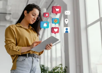 Mulher usando tablet com ícones de redes sociais flutuando ao redor, representando marketing digital e engajamento online